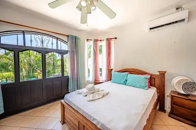 a bedroom with a bed and a window at Casa Mariposa in Jacó