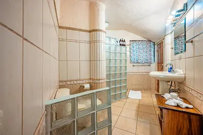 a bathroom with a sink and a toilet in it at Casa Mariposa in Jacó