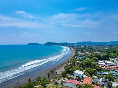 a view of a beach with houses and the ocean at Casa Mariposa in Jacó