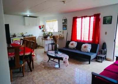 a living room with a blue couch and a kitchen at Pura Vida Tico Casita in Barva