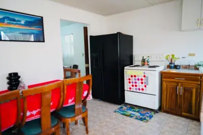 a kitchen with a black refrigerator and a stove at Pura Vida Tico Casita in Barva