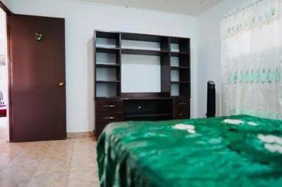 a bedroom with a bed and a dresser and a window at Pura Vida Tico Casita in Barva