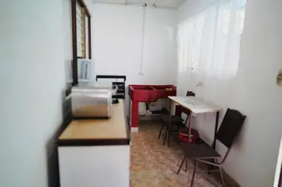 a kitchen with a counter and a table in a room at Pura Vida Tico Casita in Barva