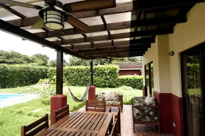 a porch with a wooden bench and a swing at Casa Lucas in Villarreal