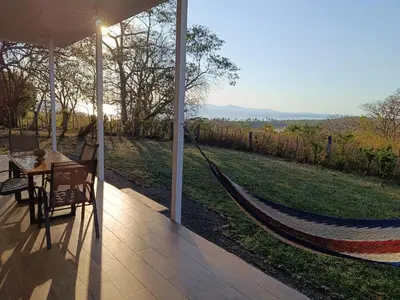 a hammock on a porch with a view of a field at Pronájem prázdninového domu in Tivives