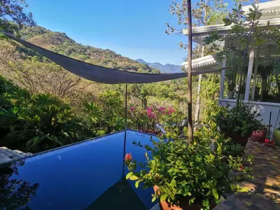 a blue fence with a hammock in a garden at Villa Turrubares in San Pablo