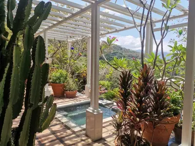 a pergola with a pool and a bunch of plants at Villa Turrubares in San Pablo