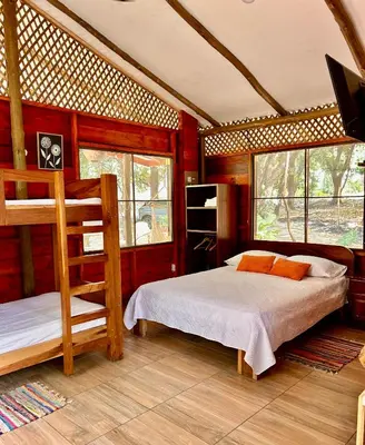 a bedroom with two bunk beds and a flat screen tv at Casa LORA Eco nature retreat in Bagaces in Bagaces