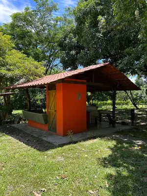a small building with a roof in the grass at Casa LORA Eco nature retreat in Bagaces in Bagaces