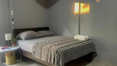 a small bedroom with a bed and a table at Roldán Lands in Huacas