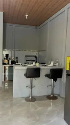 a kitchen with two bar stools and a counter at Roldán Lands in Huacas