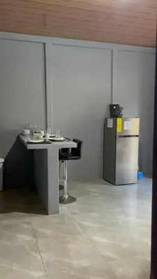 a room with a table and a refrigerator at Roldán Lands in Huacas