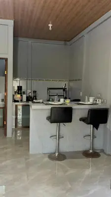 a kitchen with two bar stools in front of a counter at Roldán Lands in Huacas