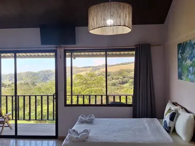 a bedroom with a bed and a large window at Mountain & sunset view Villa, Monteverde in Monteverde Costa Rica