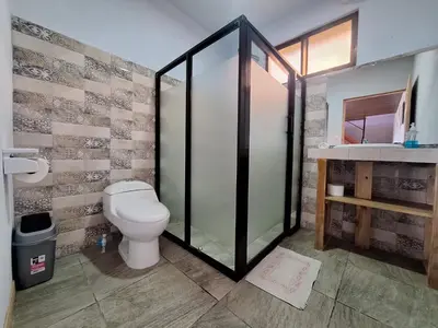 a bathroom with a toilet and a glass shower at Mountain & sunset view Villa, Monteverde in Monteverde Costa Rica