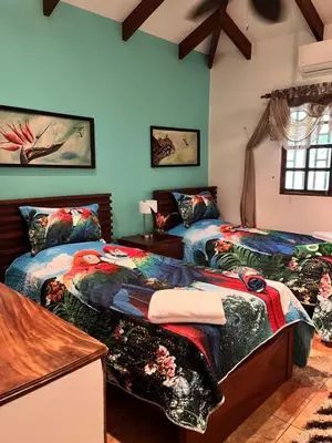 two beds in a room with blue walls at Casa Colibrí Playa Grande in Santa Cruz