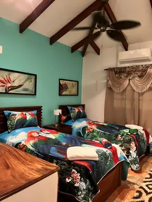 two beds in a room with blue walls at Casa Colibrí Playa Grande in Santa Cruz
