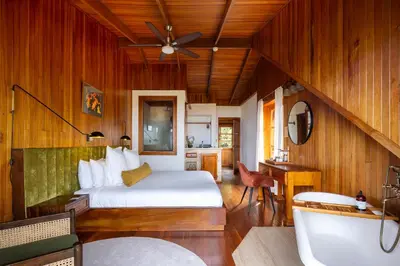 a bedroom with a bed and a tub in a room at Hotel Belmar in Monteverde Costa Rica