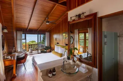 a bedroom with a bed and a bathroom with a sink at Hotel Belmar in Monteverde Costa Rica
