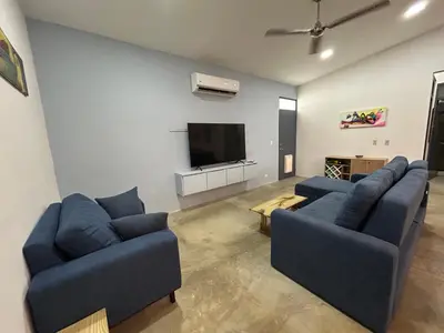 a living room with two blue couches and a flat screen tv at Bravo paraiso azul beach house in Savegre