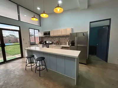 a kitchen with a large counter and two bar stools at Bravo paraiso azul beach house in Savegre