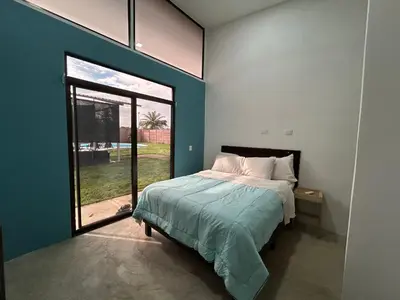 a bedroom with a bed and a large window at Bravo paraiso azul beach house in Savegre
