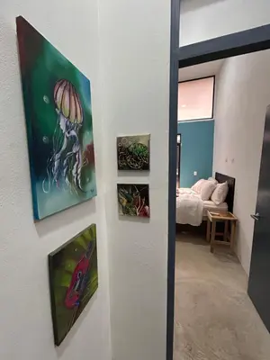 a room with paintings on the wall and a bedroom at Bravo paraiso azul beach house in Savegre