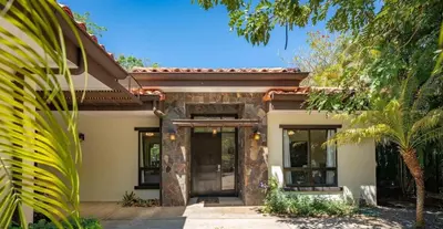 a house with a front door with trees in front at Luxe, Playa del Coco, Pacific in Coco