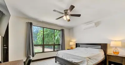 a bedroom with a bed and a ceiling fan at Luxe, Playa del Coco, Pacific in Coco