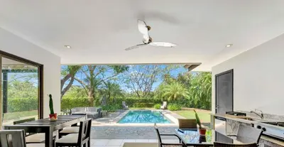 a dining room with a table and a swimming pool at Luxe, Playa del Coco, Pacific in Coco