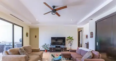 a living room with two couches and a ceiling fan at Luxe, Playa del Coco, Pacific in Coco
