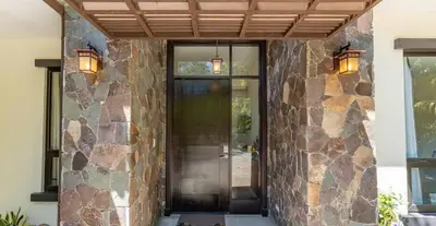 a front door of a house with a stone wall at Luxe, Playa del Coco, Pacific in Coco