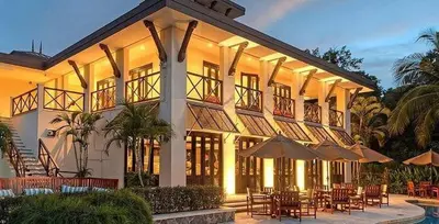a large building with tables and chairs and umbrellas at Luxe, Playa del Coco, Pacific in Coco