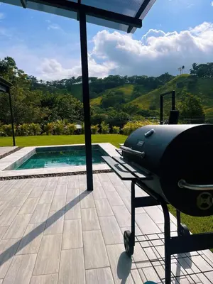 a grill sitting on a table next to a pool at Casa Nara in Sámara