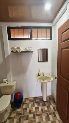 a bathroom with a toilet and a sink at Cabinas Caño Negro in Los Chiles