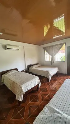 a bedroom with three beds in a room at Cabinas Caño Negro in Los Chiles