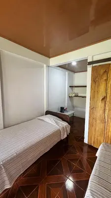 a bedroom with two beds and a wooden floor at Cabinas Caño Negro in Los Chiles