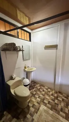 a bathroom with a toilet and a sink at Cabinas Caño Negro in Los Chiles