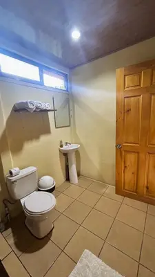 a bathroom with a toilet and a sink at Cabinas Caño Negro in Los Chiles