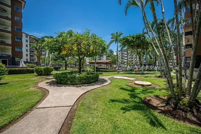 a walkway through a park with palm trees at 2-17 Jaco Beach Beautiful Costa Linda Condo in Jacó