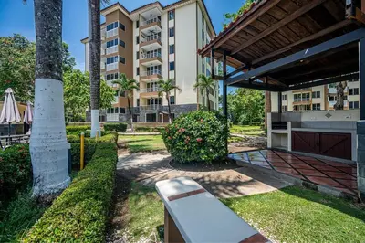 a park with a bench in front of a building at 2-17 Jaco Beach Beautiful Costa Linda Condo in Jacó