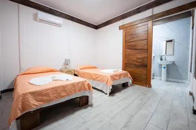 a room with two beds and a sink in it at Bay Lodge in La Cruz