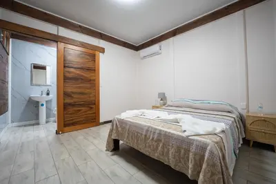 a bedroom with a bed and a bathroom with a sink at Bay Lodge in La Cruz