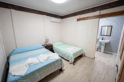 a room with two beds and a sink in it at Bay Lodge in La Cruz
