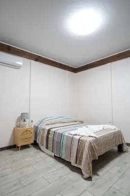 a bedroom with a bed in a white room at Bay Lodge in La Cruz