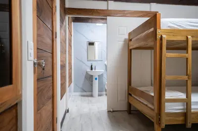 a room with a bunk bed and a bathroom with a sink at Bay Lodge in La Cruz