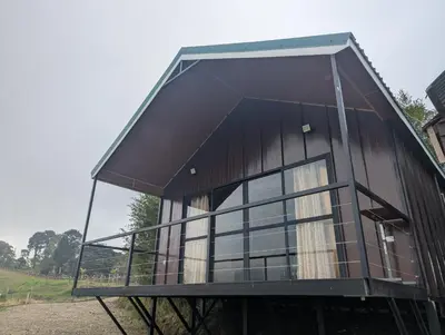 a house with a large window on top of it at Cabaña en Riverland in Zarcero