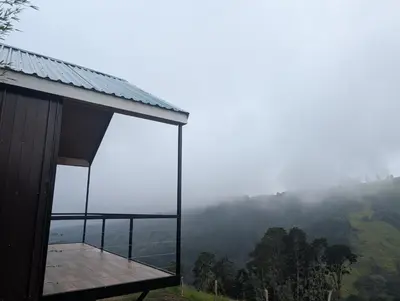 a building with a view of a hill with a foggy valley at Cabaña en Riverland in Zarcero