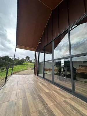 a building with large windows with a view of a golf course at Cabaña en Riverland in Zarcero