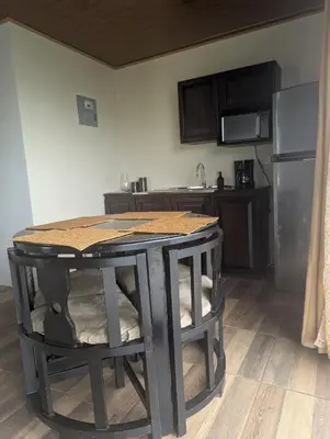 a kitchen with a black table and a kitchen with a refrigerator at Cabaña en Riverland in Zarcero